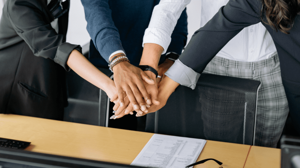 Manos juntándose como motivo de unión en equipo.