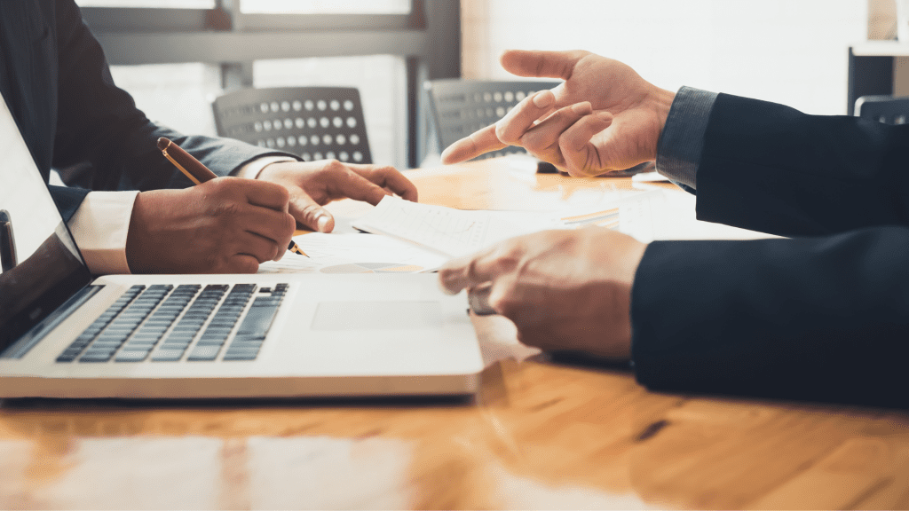 Importancia de asignar bien los roles en un equipo. Reunión de trabajo en la que se establecen los roles para un mejor funcionamiento de la empresa, vemos dos personas con un ordenador.