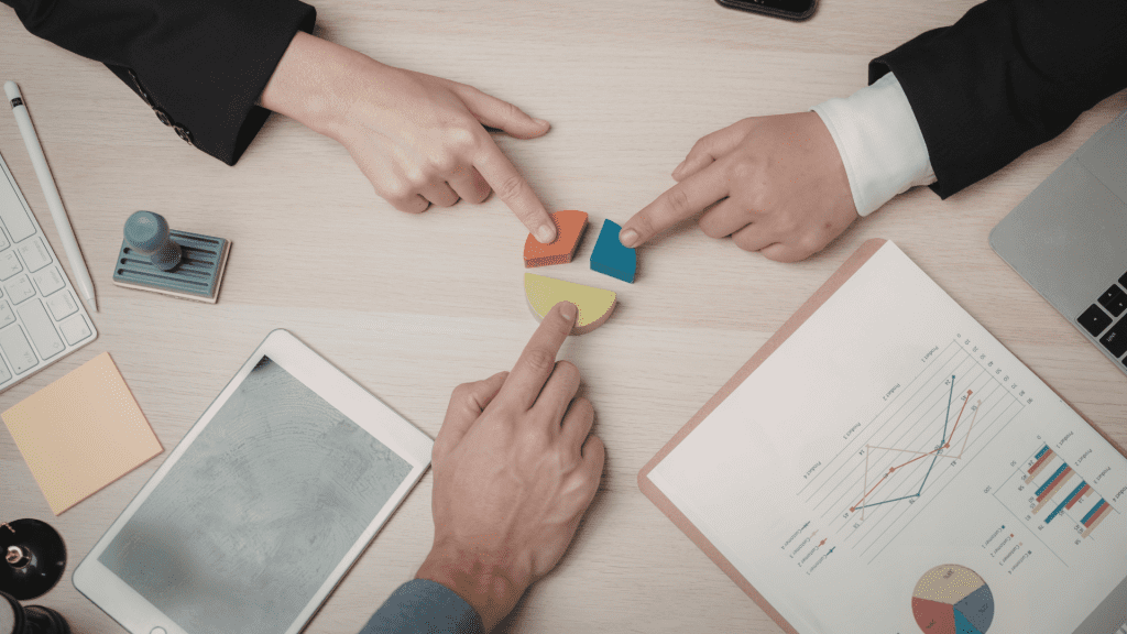 Gestión de equipos. Encontramos una mesa donde 3 manos colocan "piezas de un puzle", simulando un equipo que intenta encontrar el equilibrio.