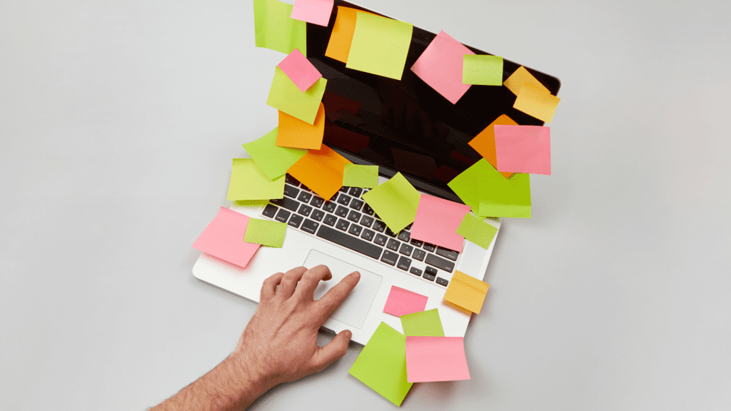 Entornos laborales accesibles. En la imagen encontramos un ordenador cubierto de post its, simulando la organización y las reuniones del equipo para hacer una empresa accesible para todos.